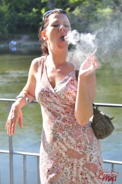 Brunette babe smoking at the riverside