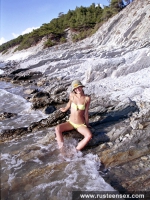 Russian teen brunette poses naked in the sea surf